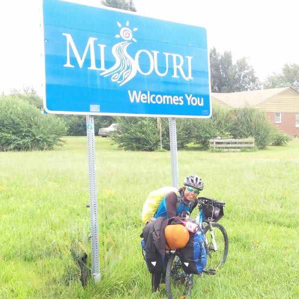 Cyclist at Missouri welcome sign