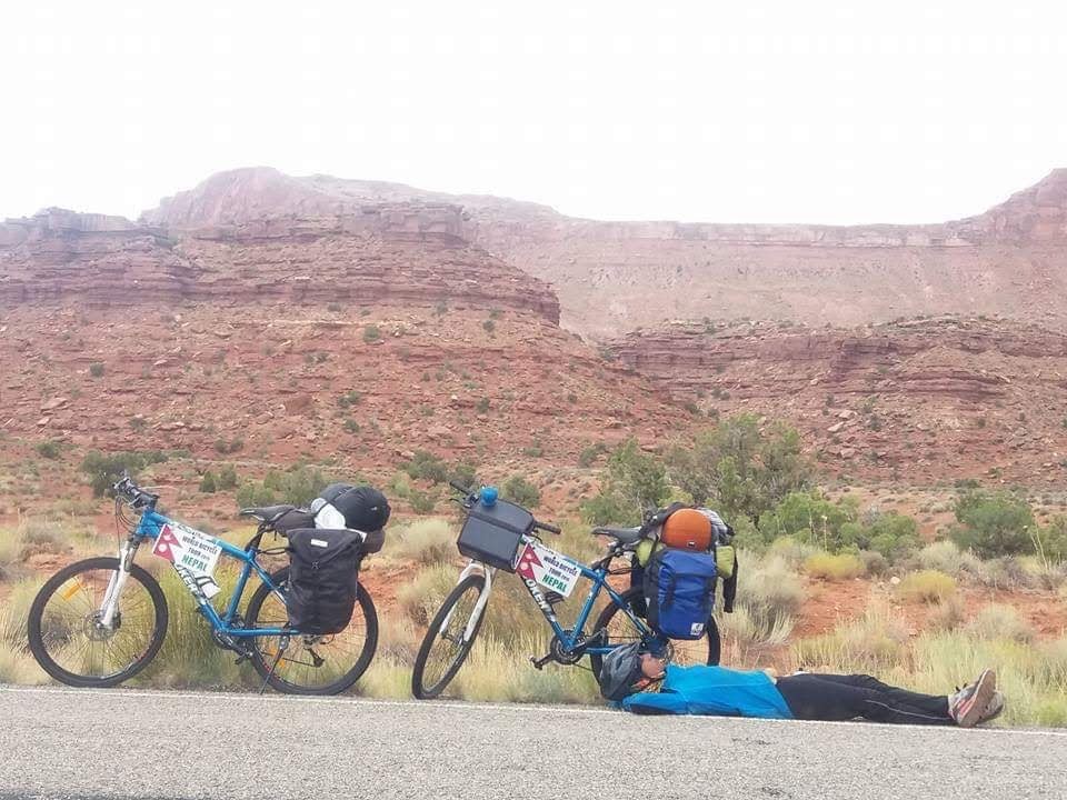 Two cyclists resting in a desert landscape